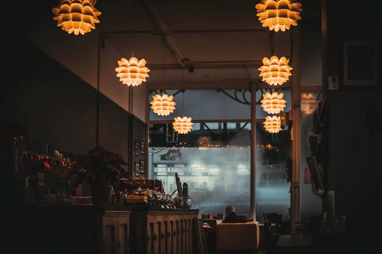 The dining room at night under warm hanging lights