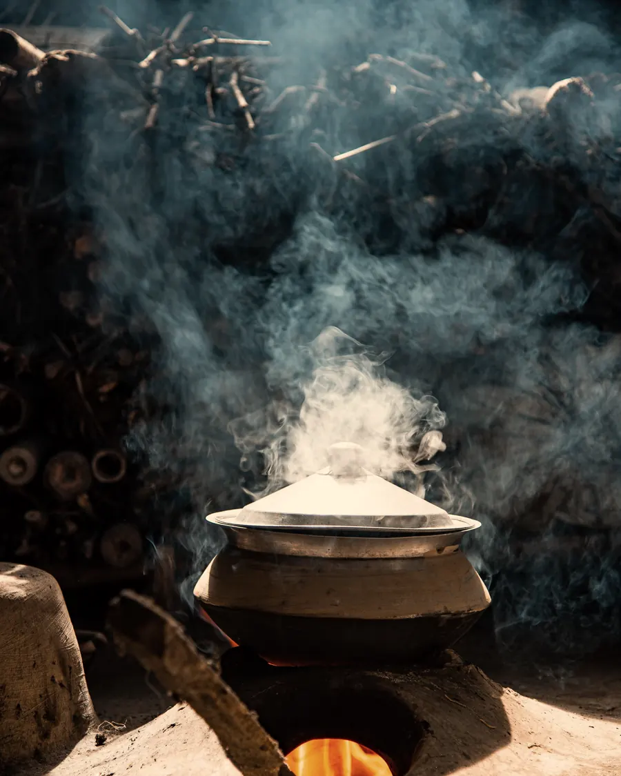 Steam rising from a pot on the coals
